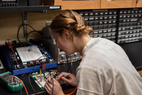 Student working on an electrical circuit board